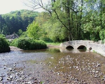 Scene showing Gallox Medieval Packhorse Bridge over the River Avill, Dunster, Somerset, England