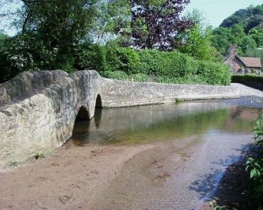 View of Gallox Bridge, a medieval packhorse bridge over the River Avill, Dunster, Somerset, England