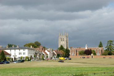 Part of Long Melford village green showing the church and the tudor Trinity Hospital.