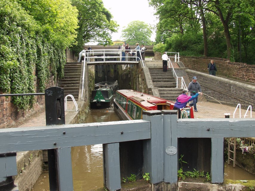 View of two canal narrowboats negotiating a series of locks on the Shropshire Union Canal, Chester, Cheshire, Great Britain