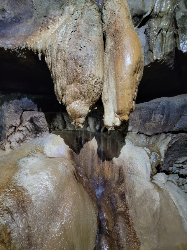 Water running down a calcite formation in the main stream passage, Ingleborough Cave, Clapham, Yorkshire, England, Great Britain