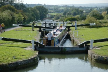 Scene showing a narrowboat descending Caen Hill Locks, Rowde, Devizes, Wiltshire (Wilts), England