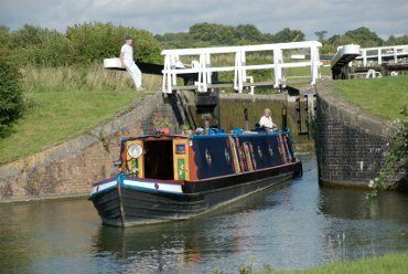 View of a narrowboat emerging from a lock, Caen Hill Locks, Rowde, Devizes, Wiltshire (Wilts), England